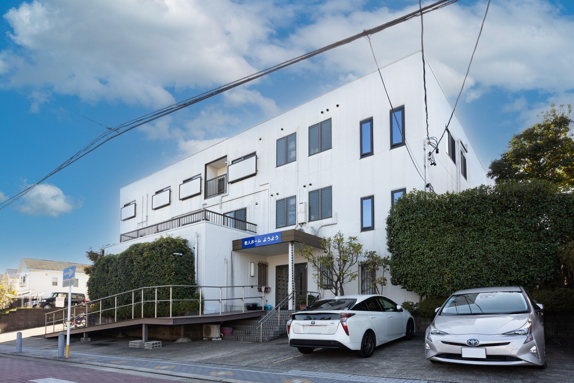 車椅子に乗った男性とその車椅子を押している女性が、自然の中で景色を眺めている。