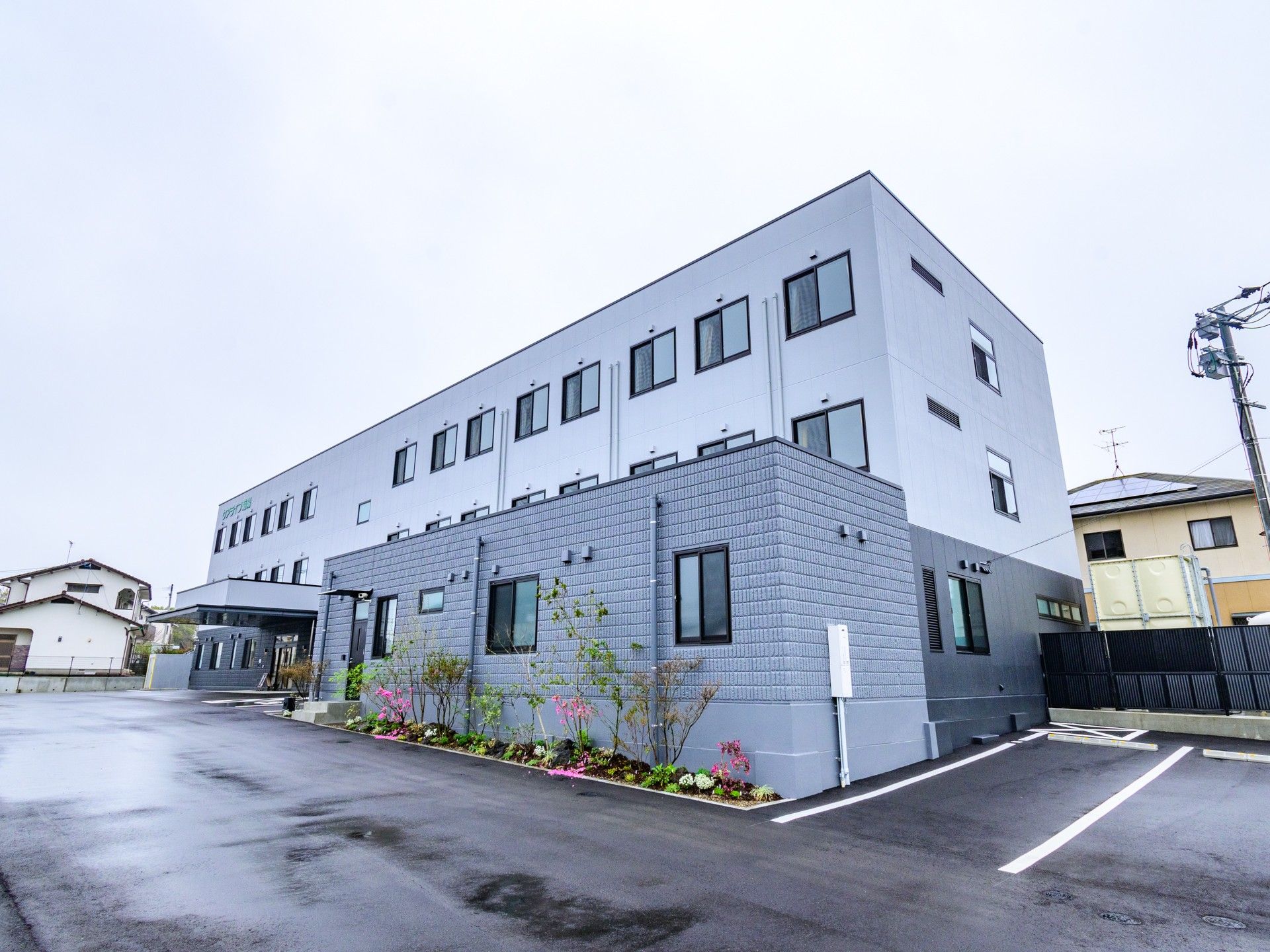 駐車場と3階建ての建物
