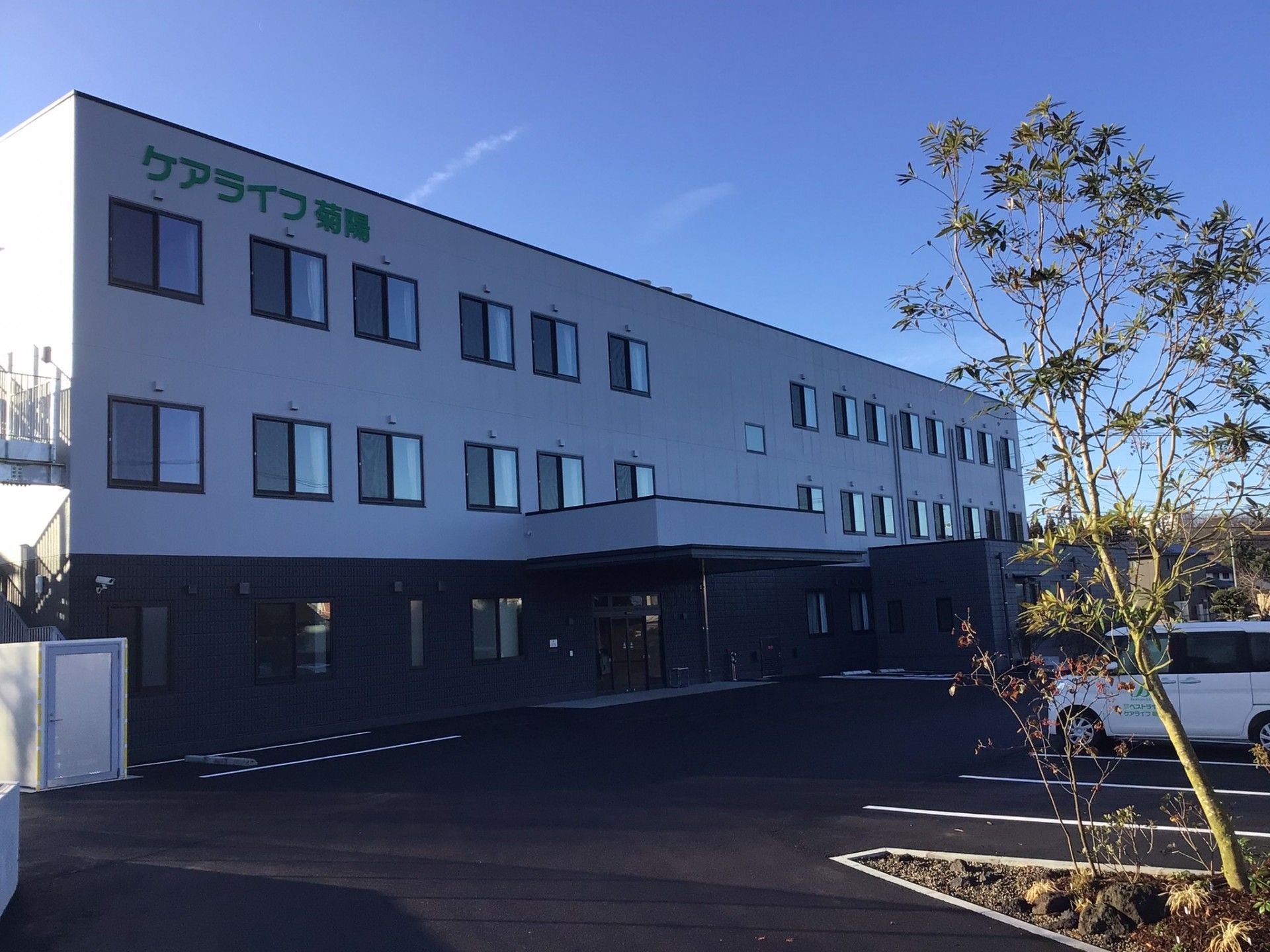 駐車場と3階建ての建物