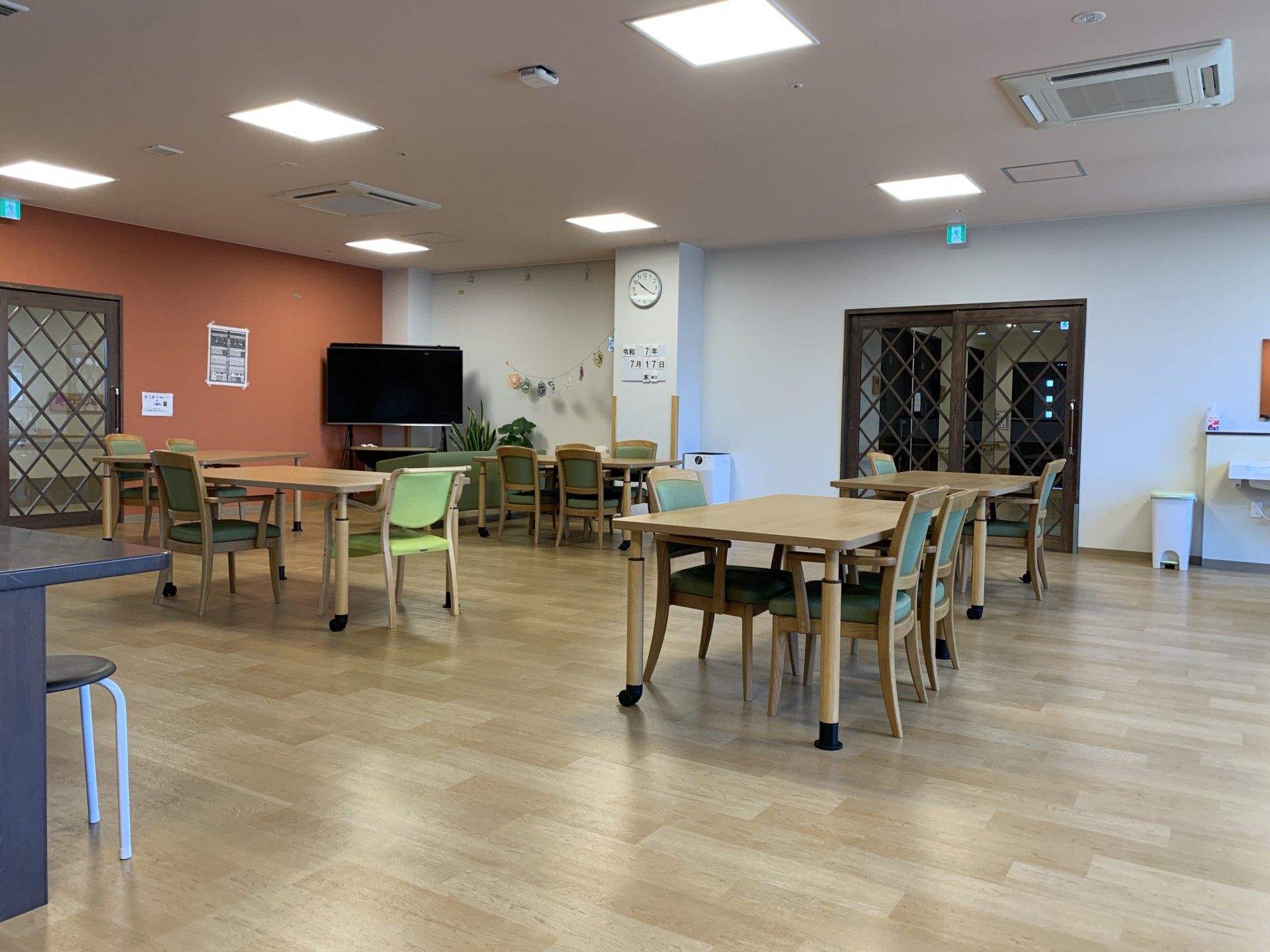 メガネをかけたご高齢の男性がコーヒーを片手に新聞を読んでいる。