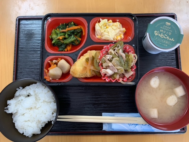 お盆にセットされた4品のおかずとご飯、お味噌汁とデザート