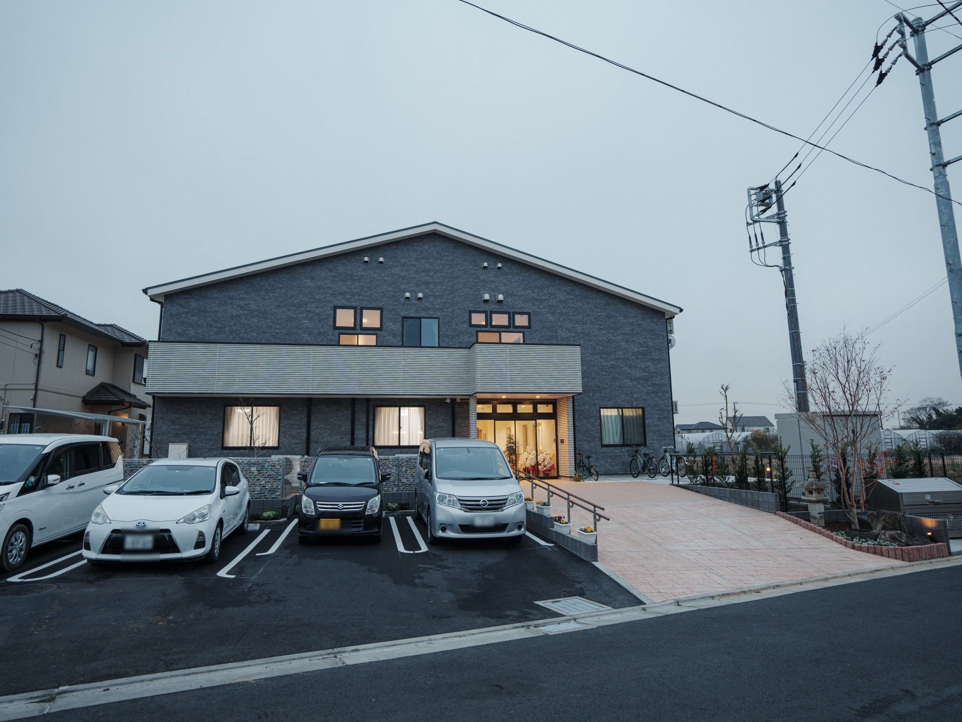 落ち着いた色合いの建物。眼に前には駐車場。