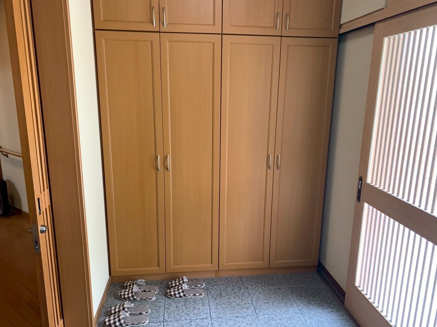 木製の収納とスリッパの玄関