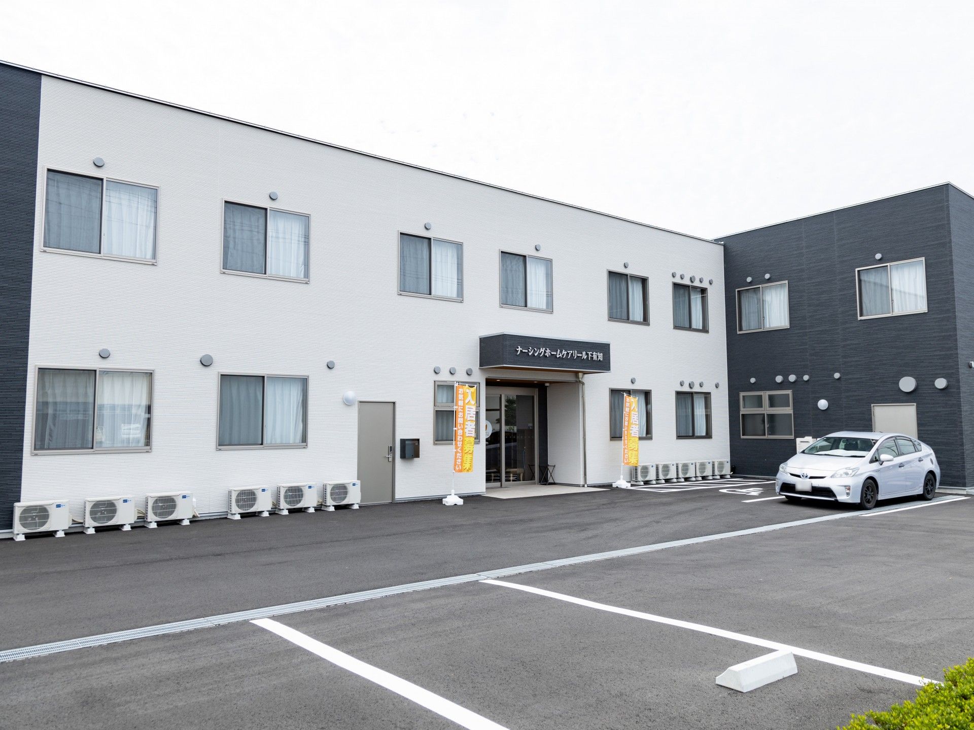 紺色、茶色、白色の外壁の2階建て建築物