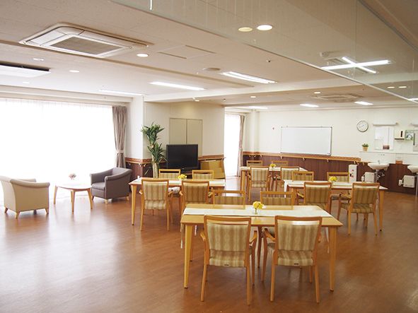 木製のテーブルに椅子がセットされて数組置かれている。奥には一人掛けのソファーもある。各テーブルの間は広いスペースが取られている。