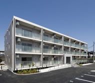 車いすに座った女性と、男女の看護師二名が楽しそうに談笑している様子。