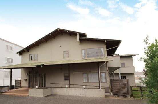 茶色い外壁で三角屋根の2階建てグループホーム