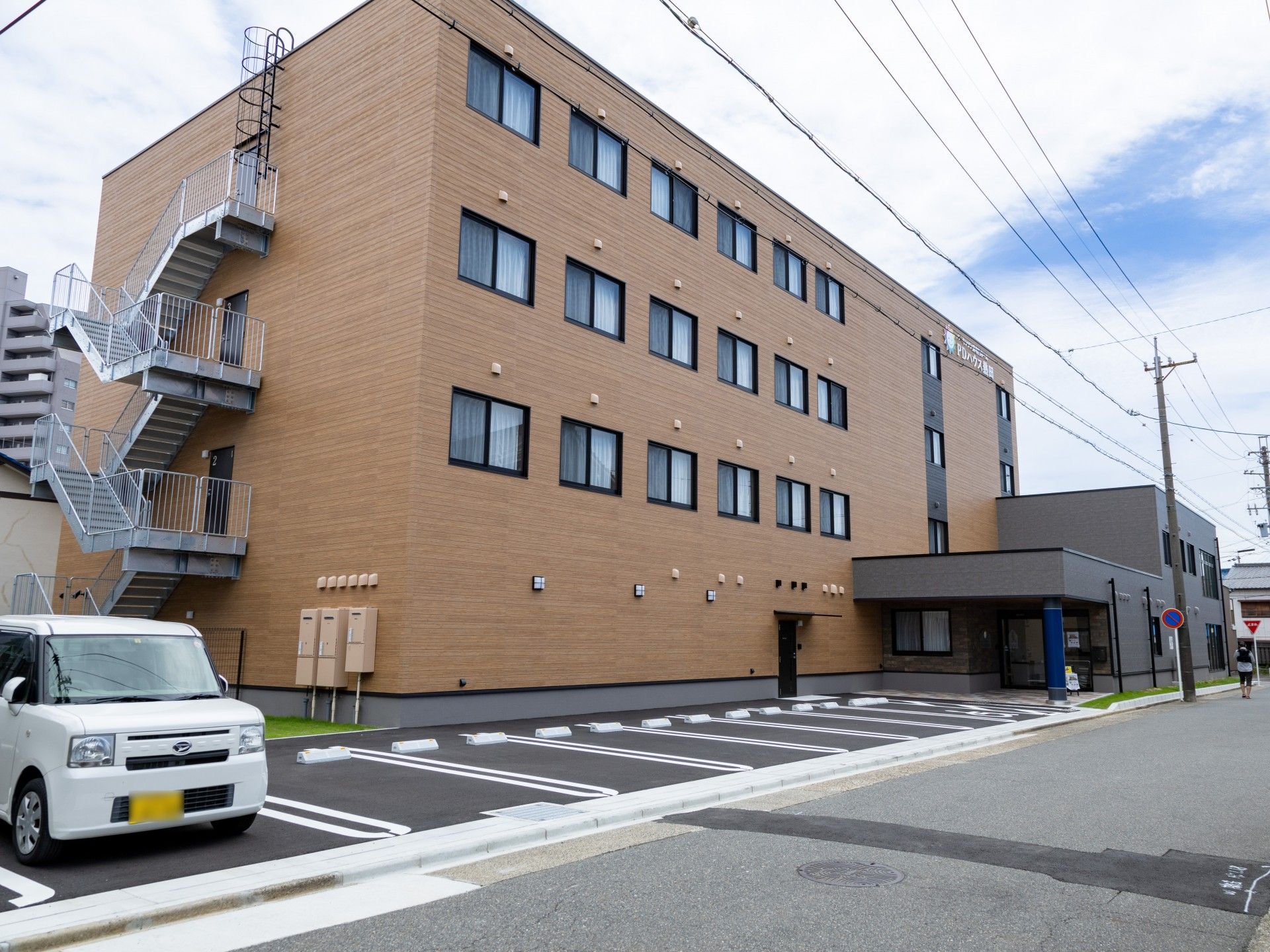 笑顔で廊下を歩く高齢者と職員