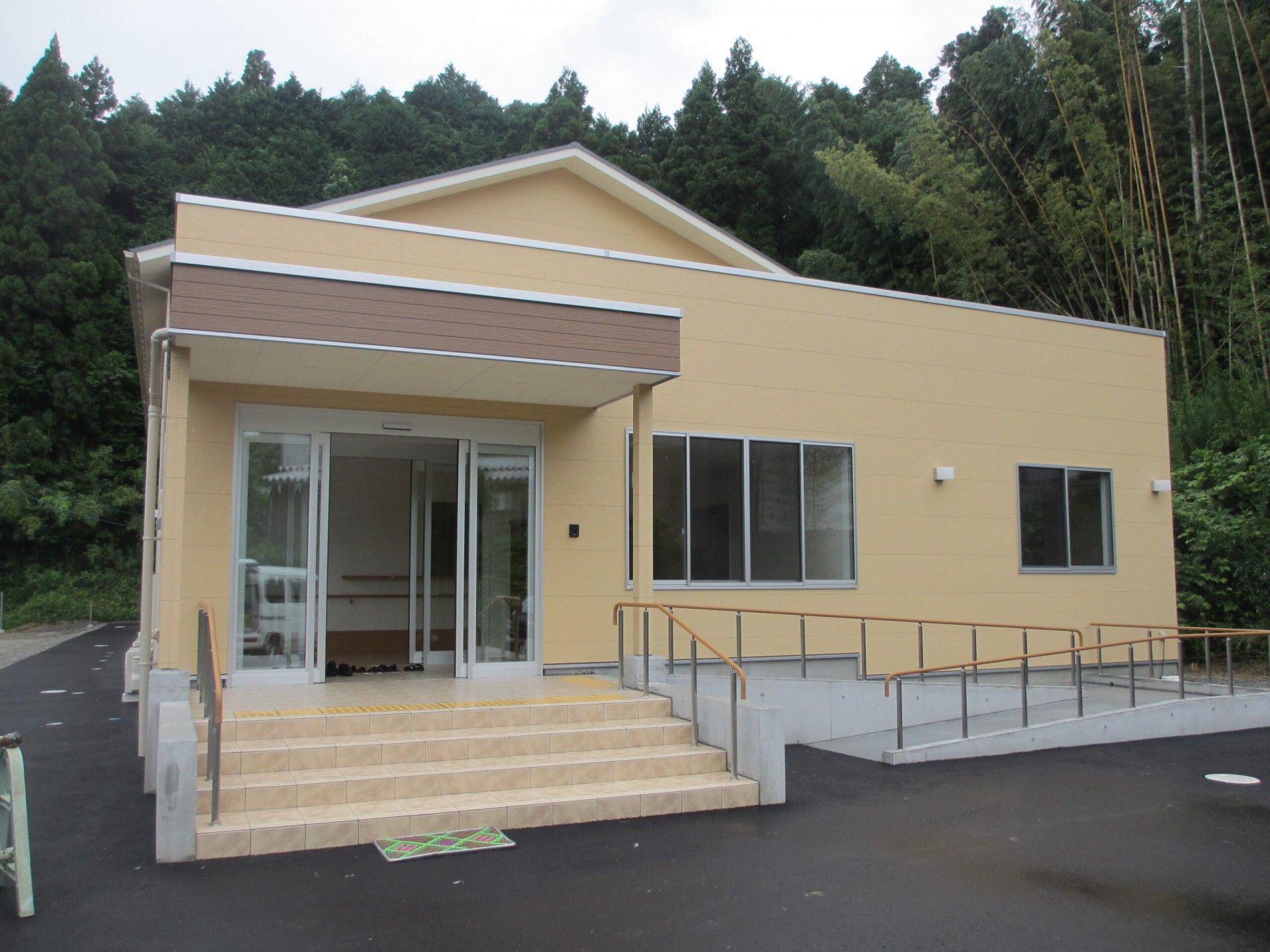 三角屋根で薄い黄色の2階建て建築物