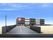 広い駐車場があるモノトーンの外壁の3階建て建築物