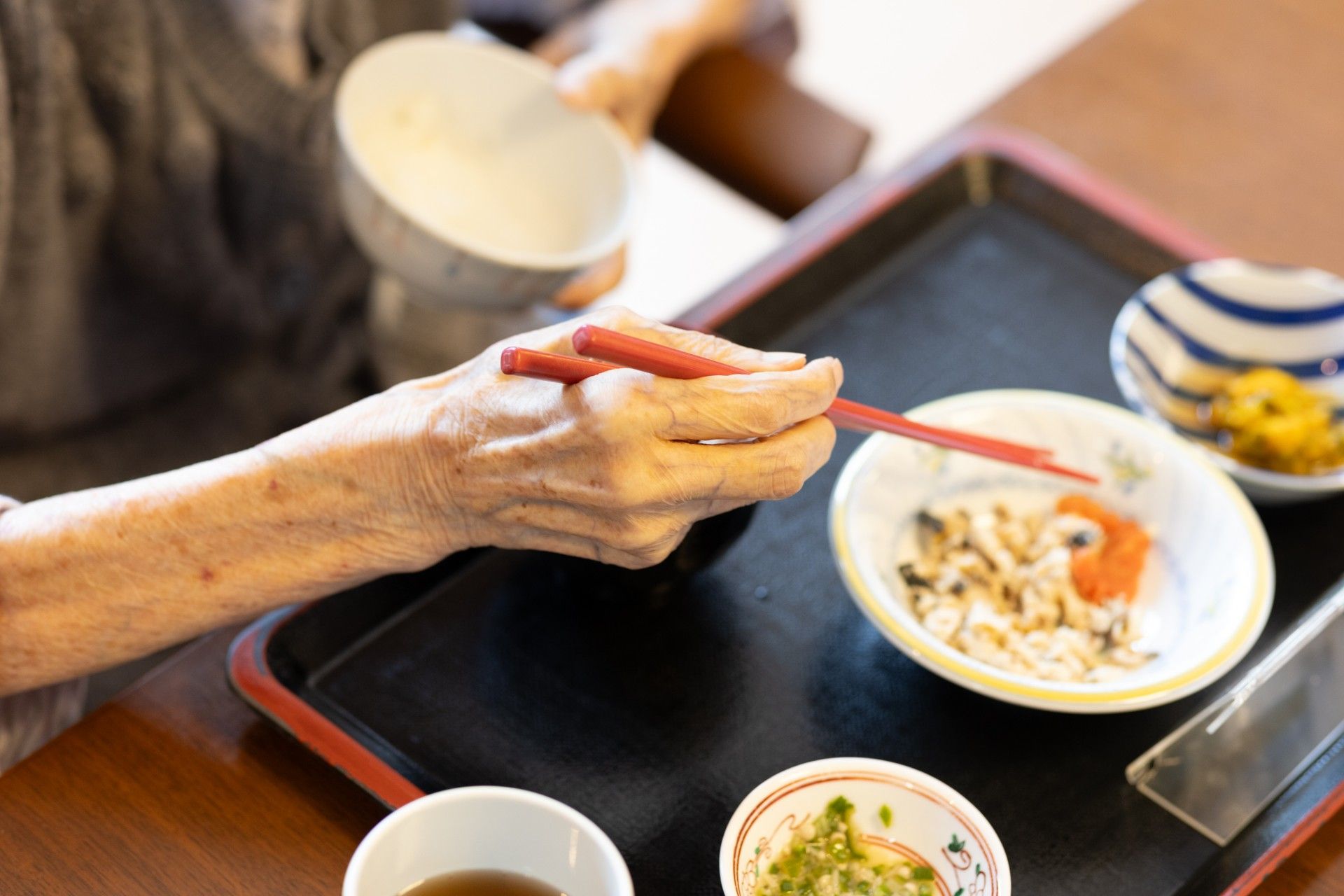 ベッドで過ごす高齢者とお見舞いの家族