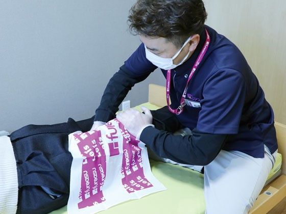 入居者の足にマッサージを行うスタッフ
