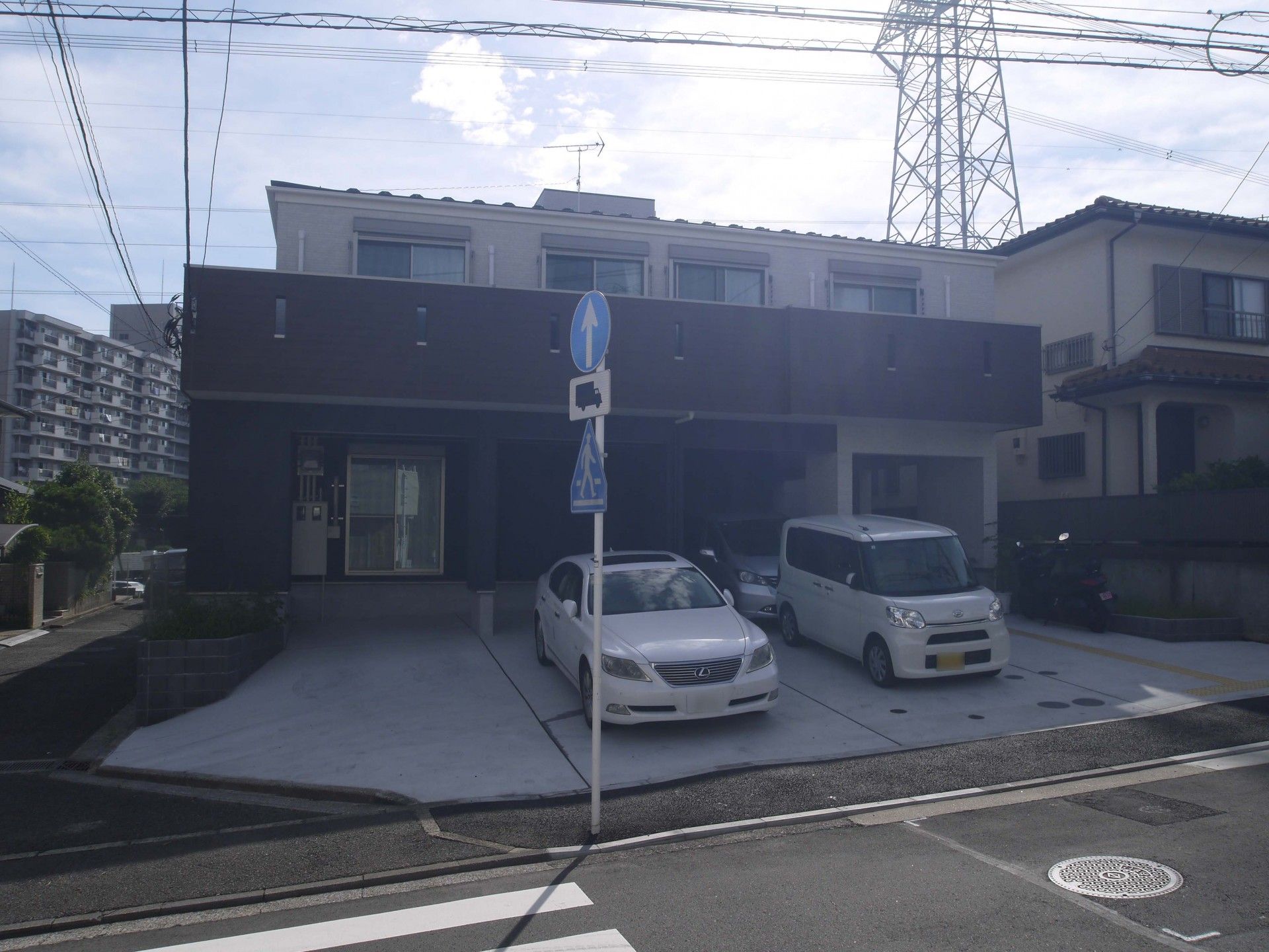 ベージュと紺の外壁で三角屋根の3階建てグループホーム