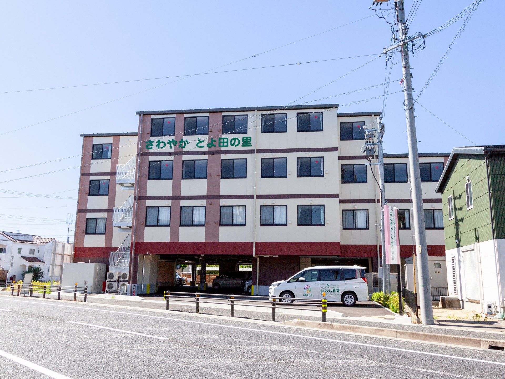 さわやかとよ田の里と緑色の字で書かれており、ベージュの外壁の3階建て老人ホーム。