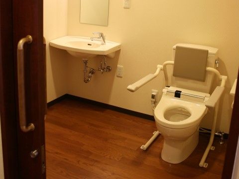 すこや家・北新横浜の居室トイレ。居室内には個人専用のトイレが備わっております。手すりの付いたバリアフリー設計です。