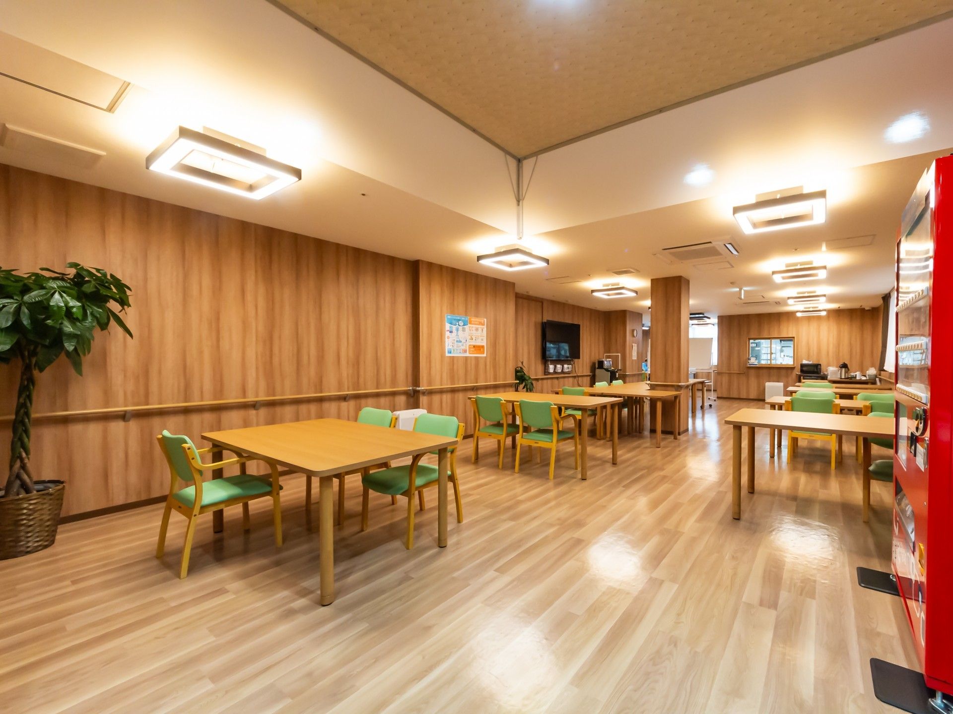 ベージュと薄茶のツートンカラーの外壁の3階建て老人ホーム