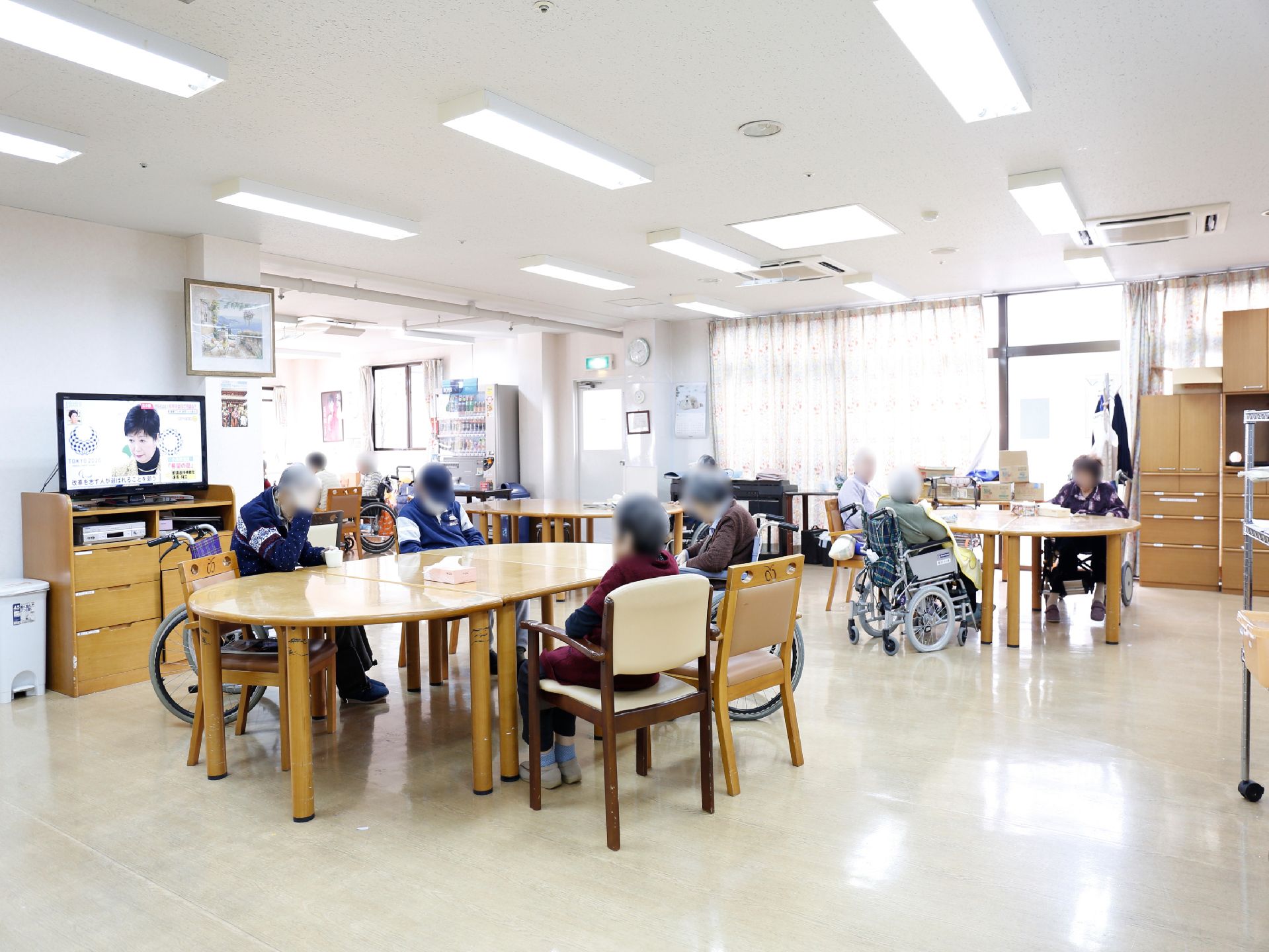 リビングに集まっている、椅子や車椅子に座っている入居者