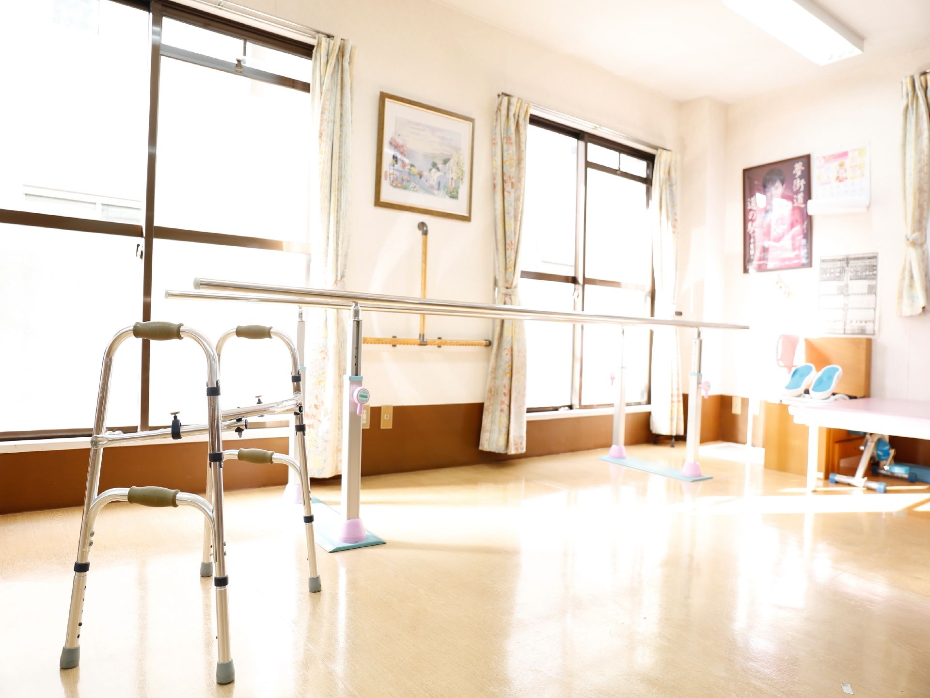 窓からは明るい光がフローリングの部屋に差し込んでいる。壁には絵画なども飾られており、手間には歩行のトレーニングのための機材が置かれている。