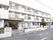 白い外壁の3階建のマンションのようなつくりになっている。ベランダにはフェンスがあり入り口には施設名の入った雨よけがついている。