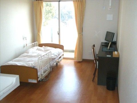 採光に配慮した大きい窓があり、ベッドや家具が機能的に配置された居室