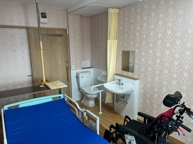 車いすに乗っている男性と寄り添う介護スタッフ