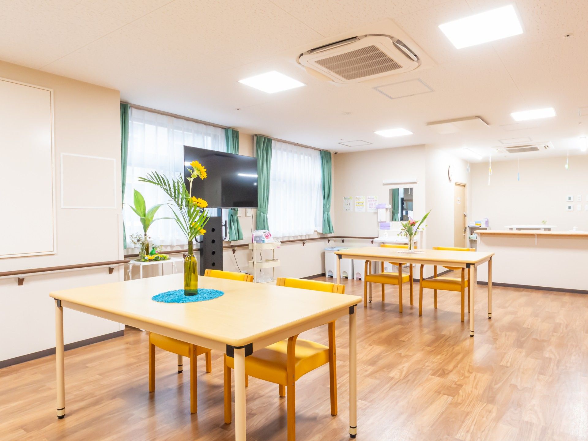 ベッド上で起き上がっている高齢の男性とお見舞いの家族