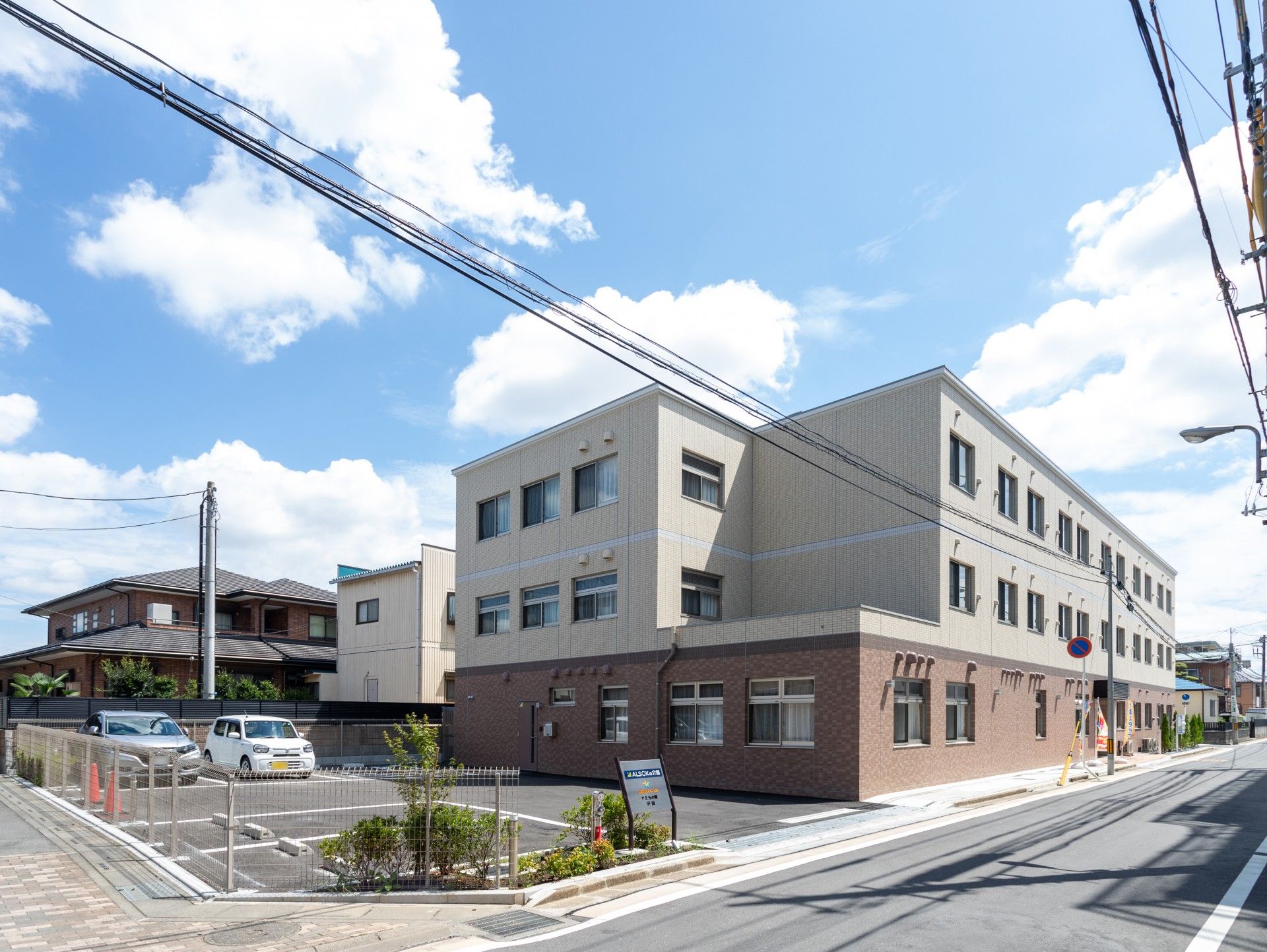 1階が茶色、2階3階がベージュの外壁の3階建て老人ホーム
