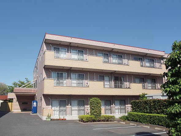 ピンクを基調とした三階建ての施設。広々とした駐車スペースが確保されており、気軽に訪れることができる。