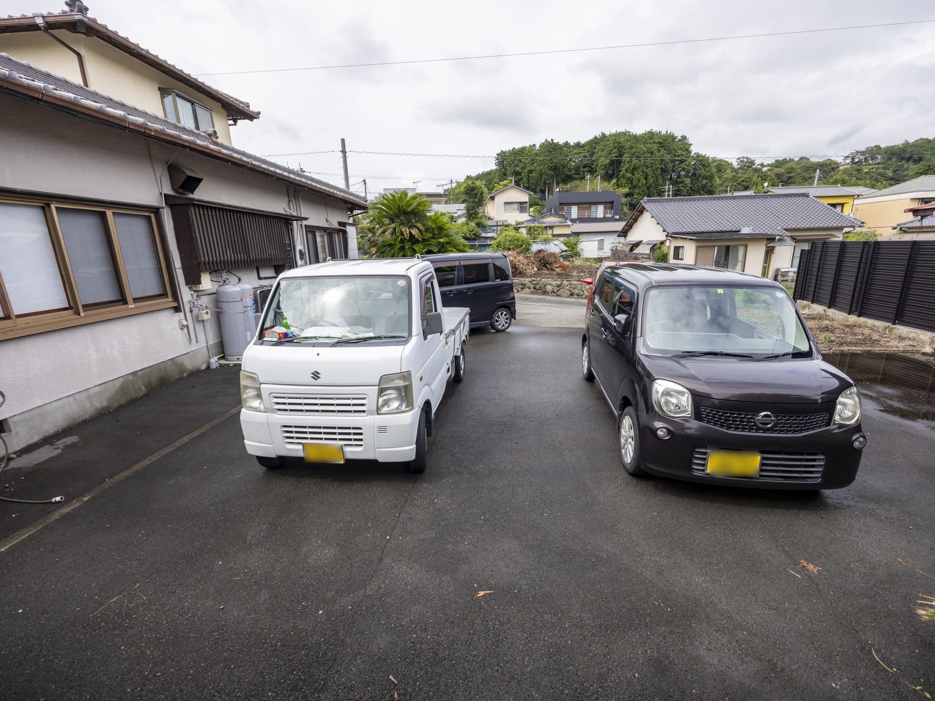 白と黒の車が停まる駐車場