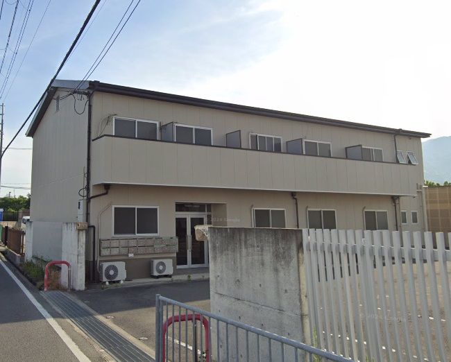 アイボリーの外壁で三角屋根の2階建て住宅