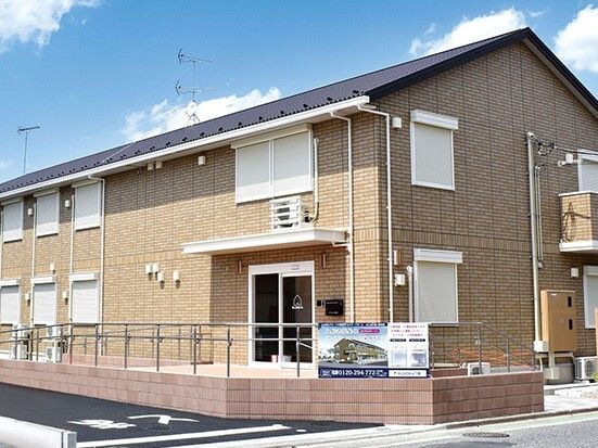 ピンク系２トーンカラーの外壁の２階建ての建物。小規模な建物からはアットホームな雰囲気を感じることができる。
