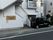愛恩ガーデンハウス品川と書かれた看板が掲げられ、黒い車両が止まっている住宅