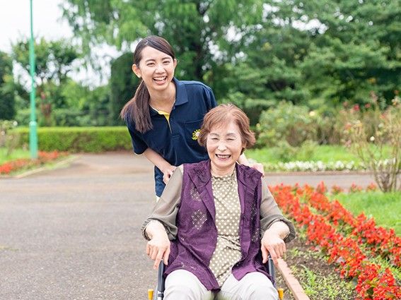 笑顔で散歩するスタッフと利用者