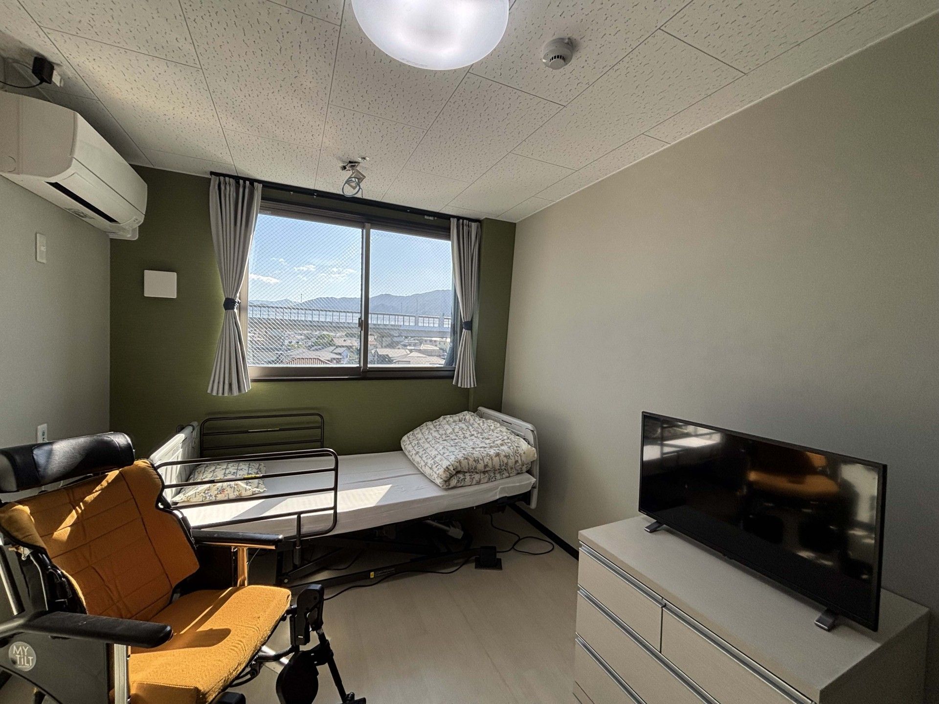 窓際のベッドと車椅子