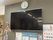壁掛けテレビと時計のある部屋