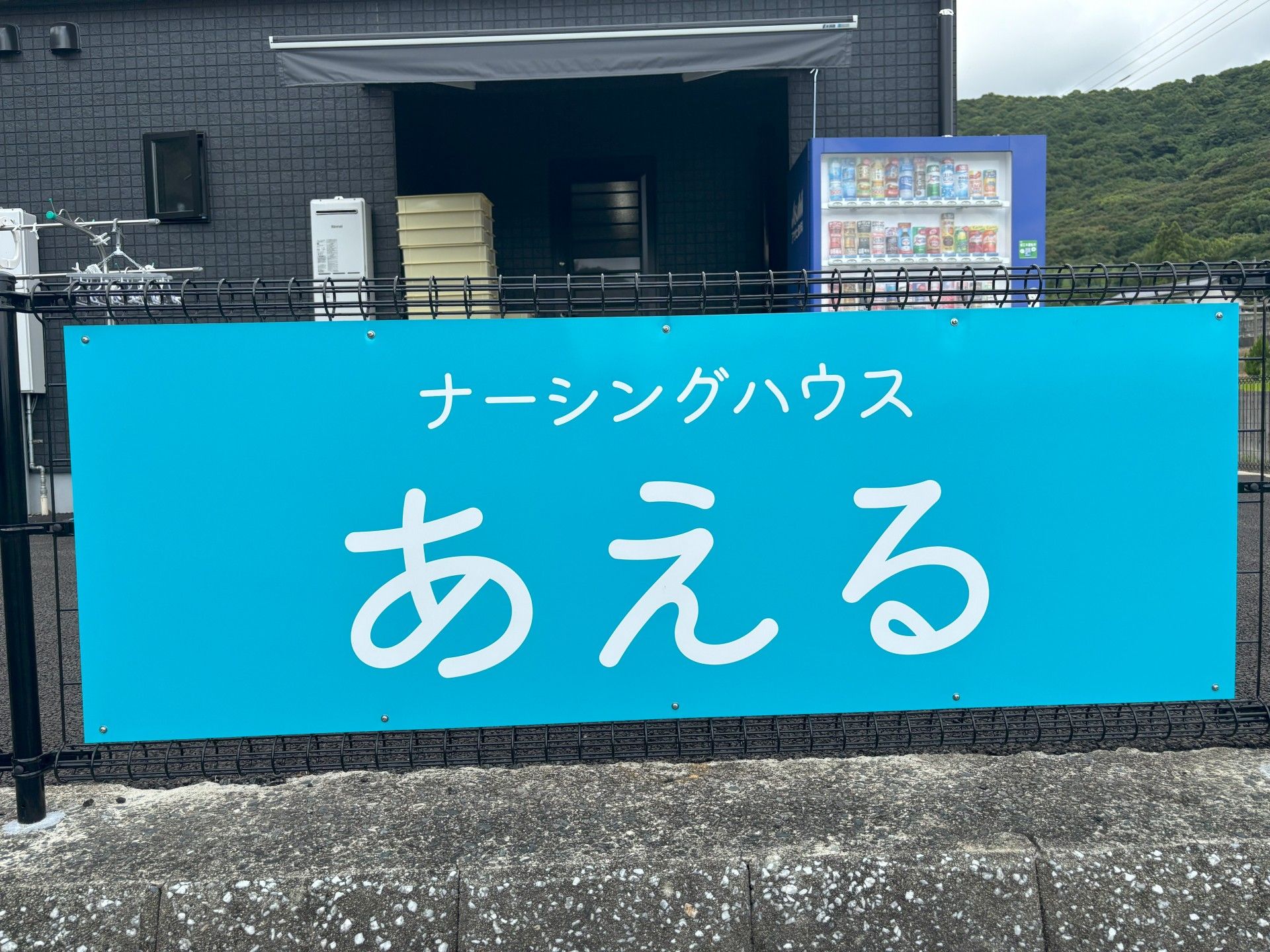青い看板の建物前
