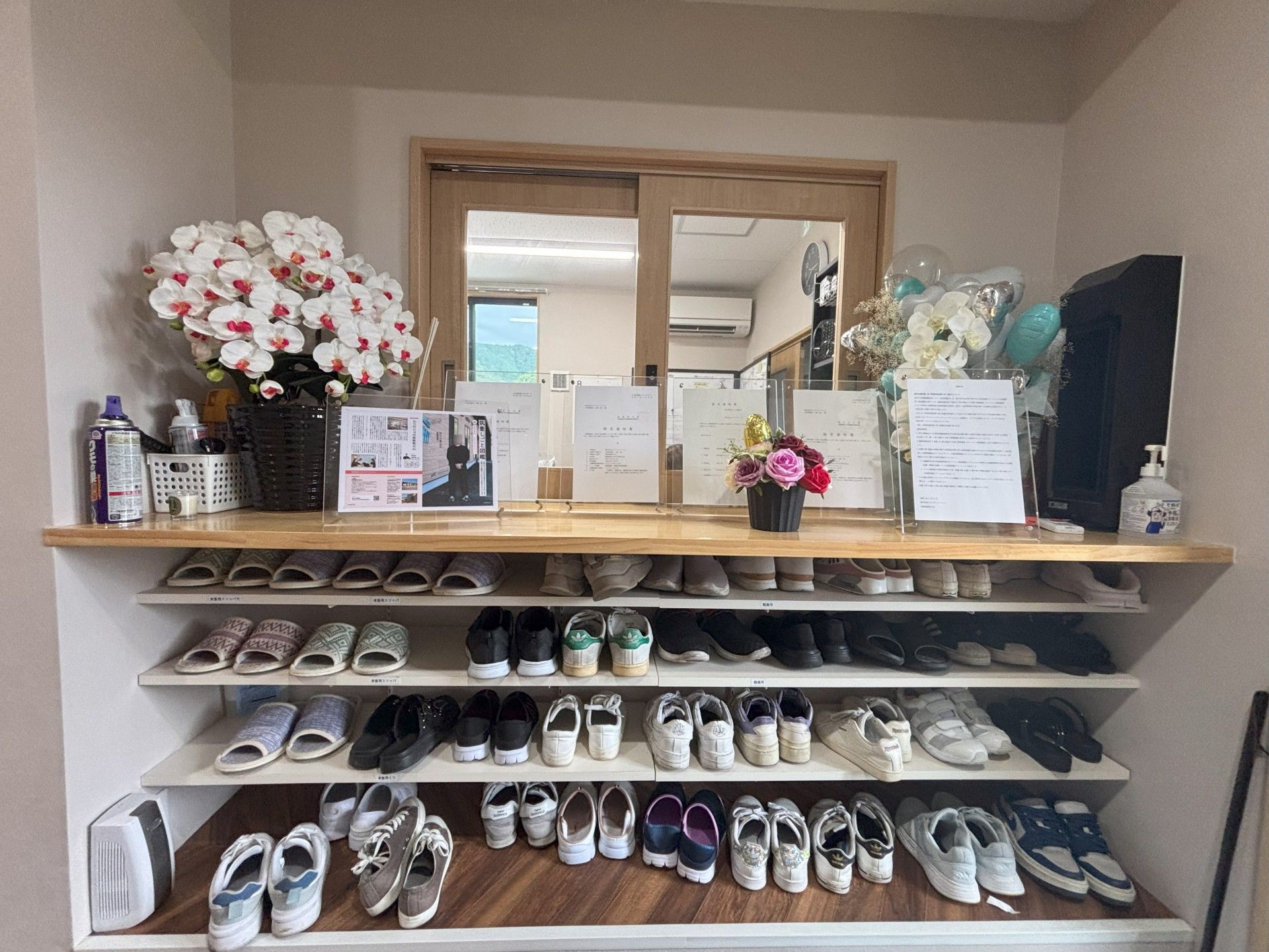 靴が並ぶ棚と花