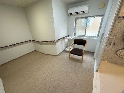 車椅子に座っている男性と寄り添う介護スタッフ