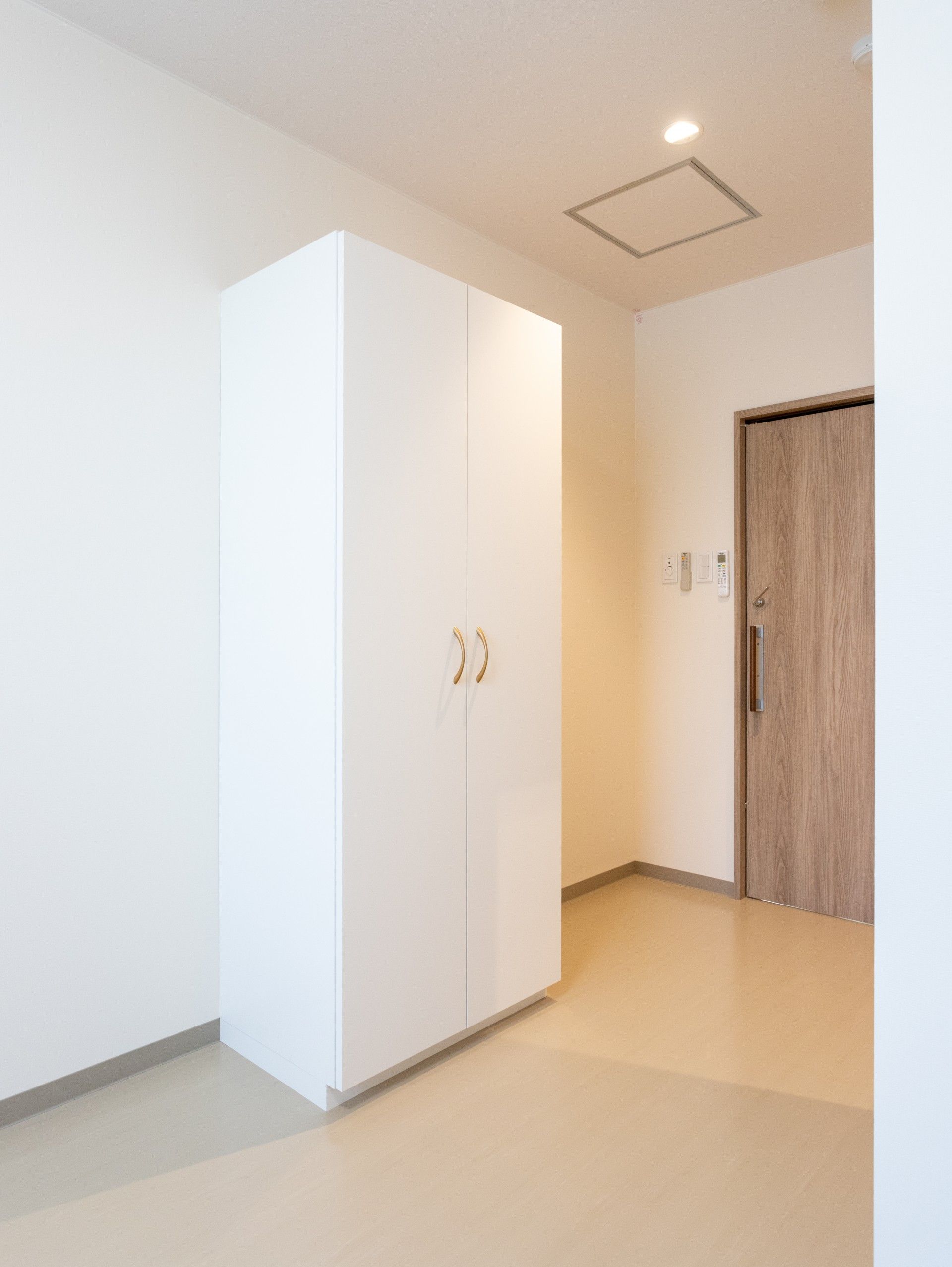 白い収納と木製ドアの部屋