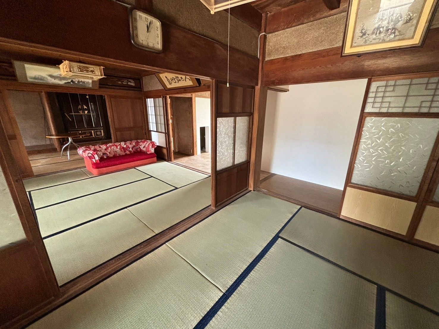 赤いソファがある畳敷きの居間と和室