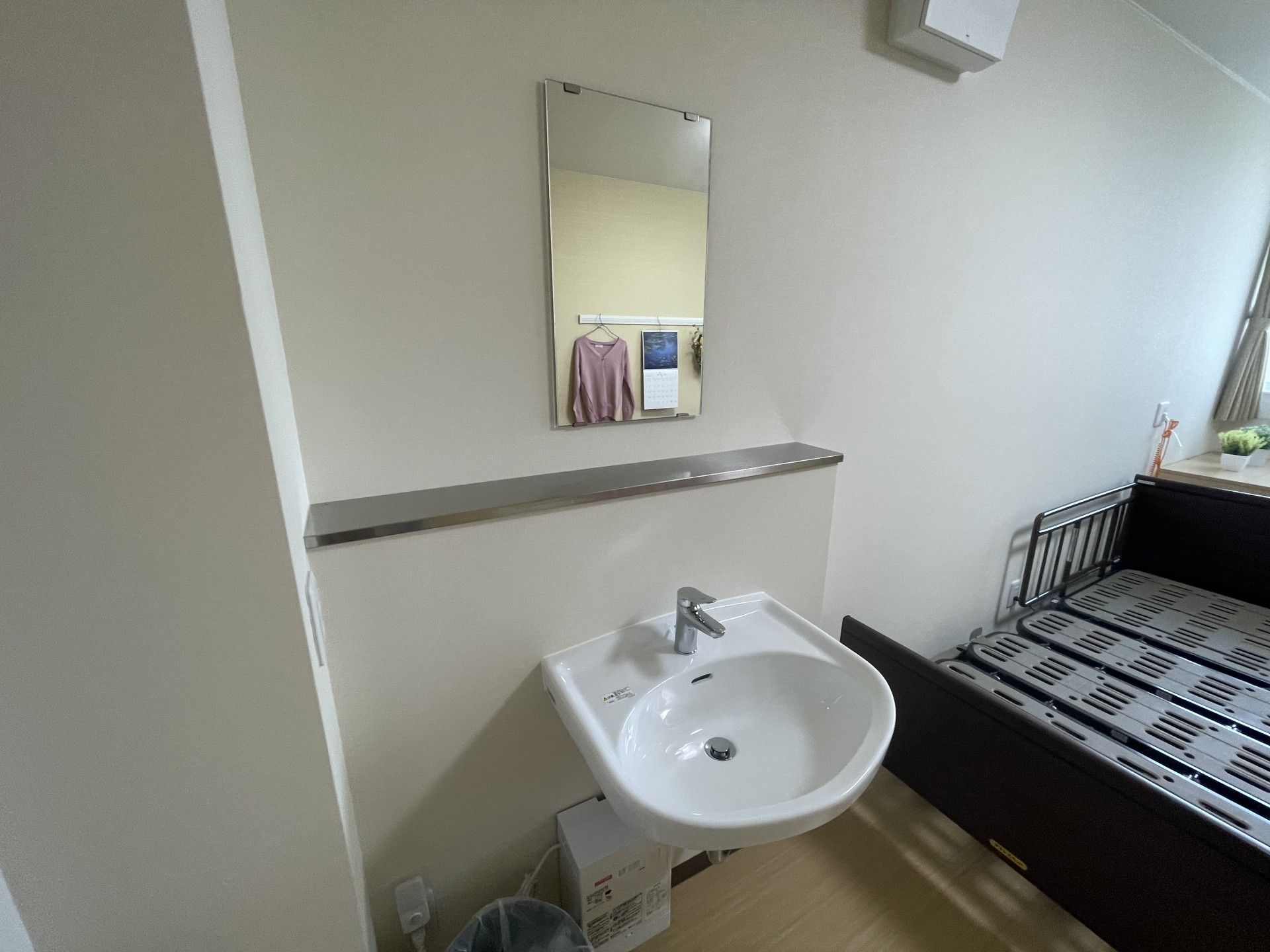 洗面台とベッドのある部屋