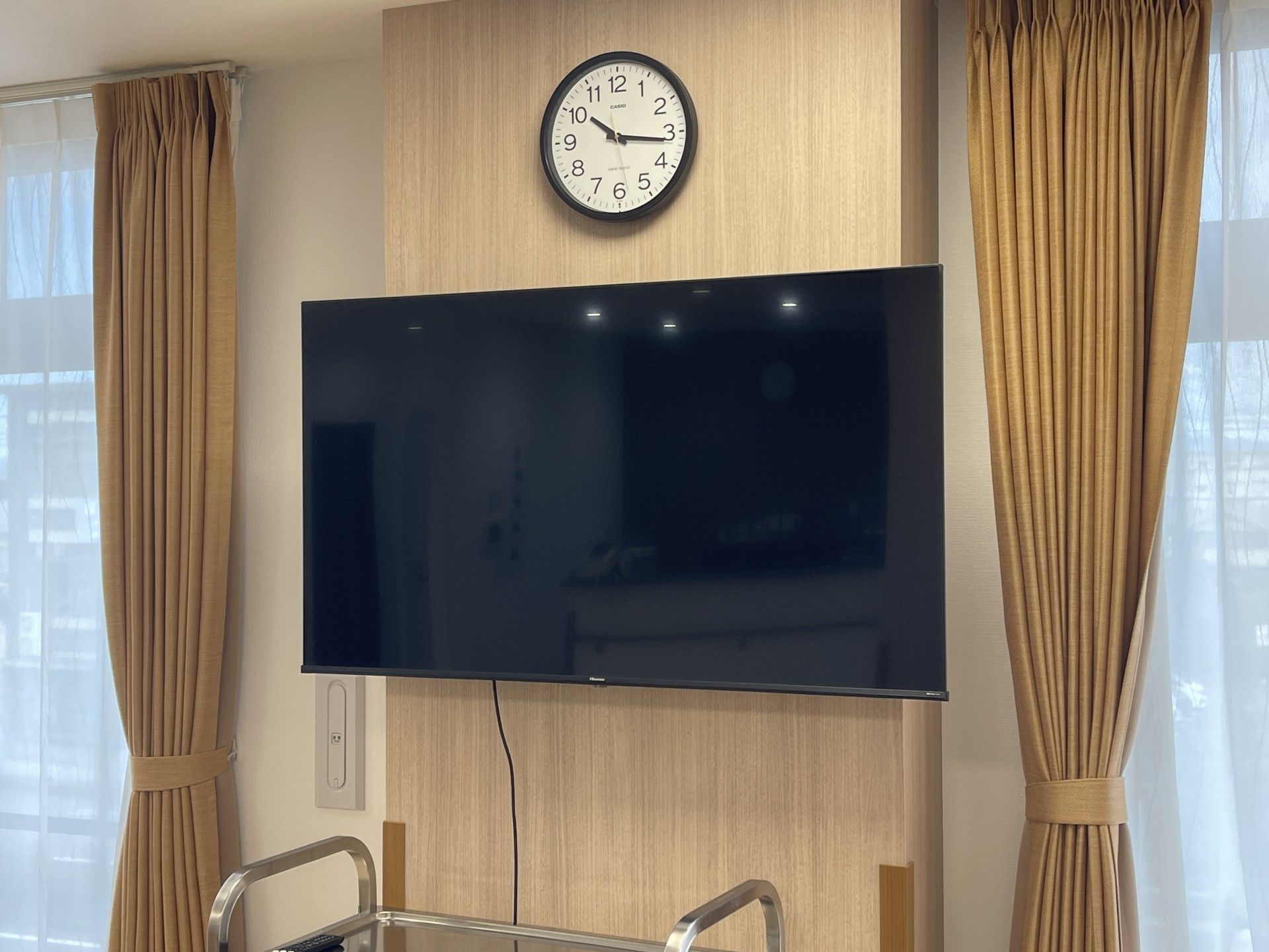 大きなテレビと時計の壁