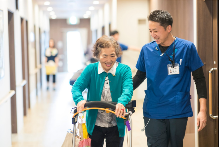 笑顔で歩く利用者と職員の廊下