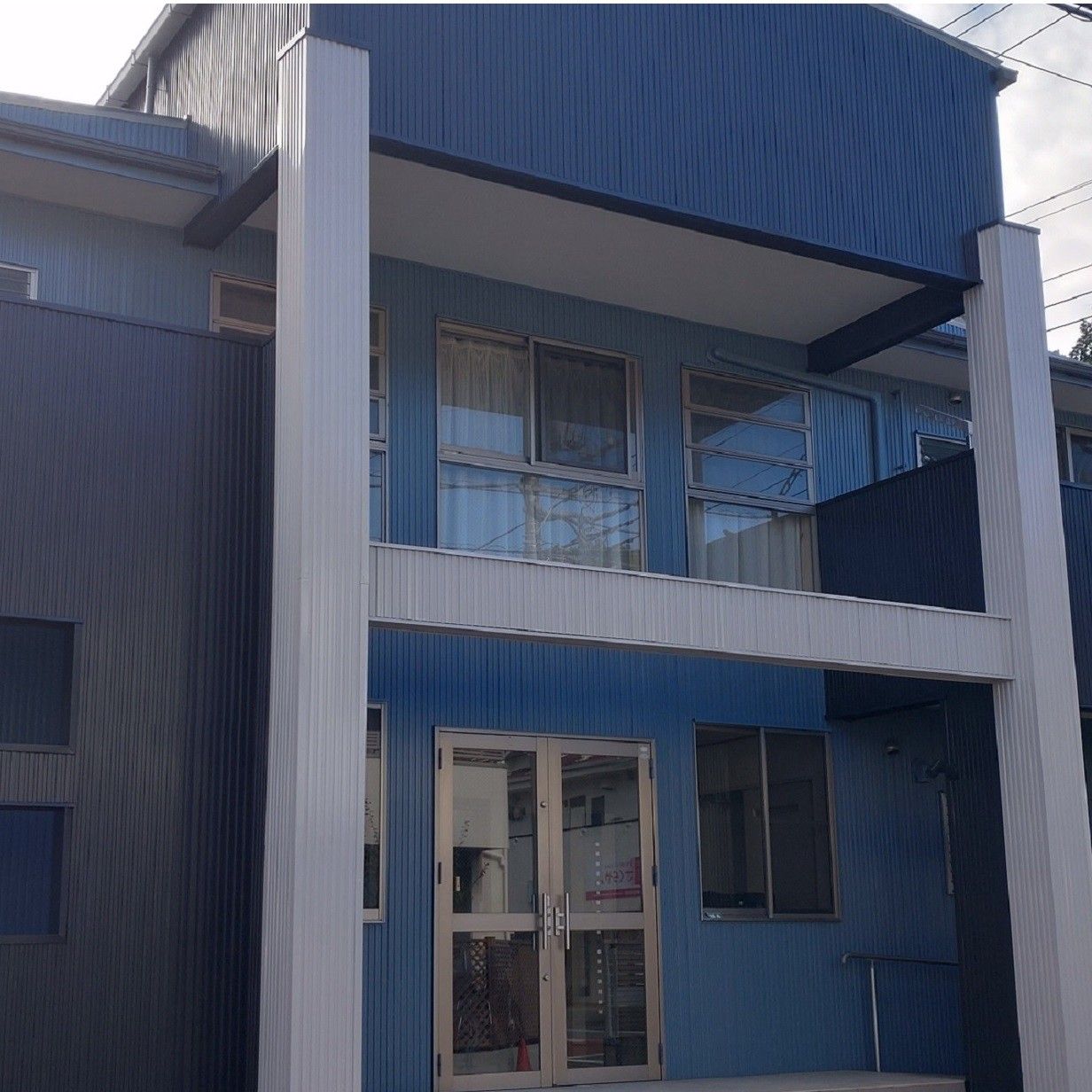 青い外壁の建物入口