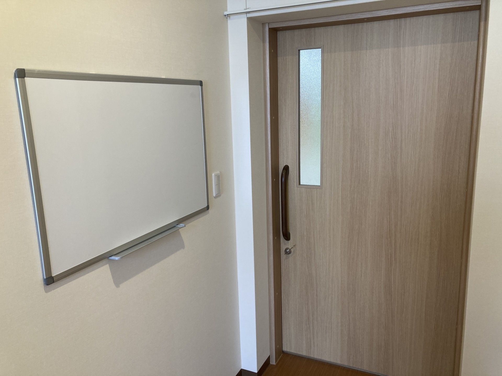 ホワイトボードと木製ドア