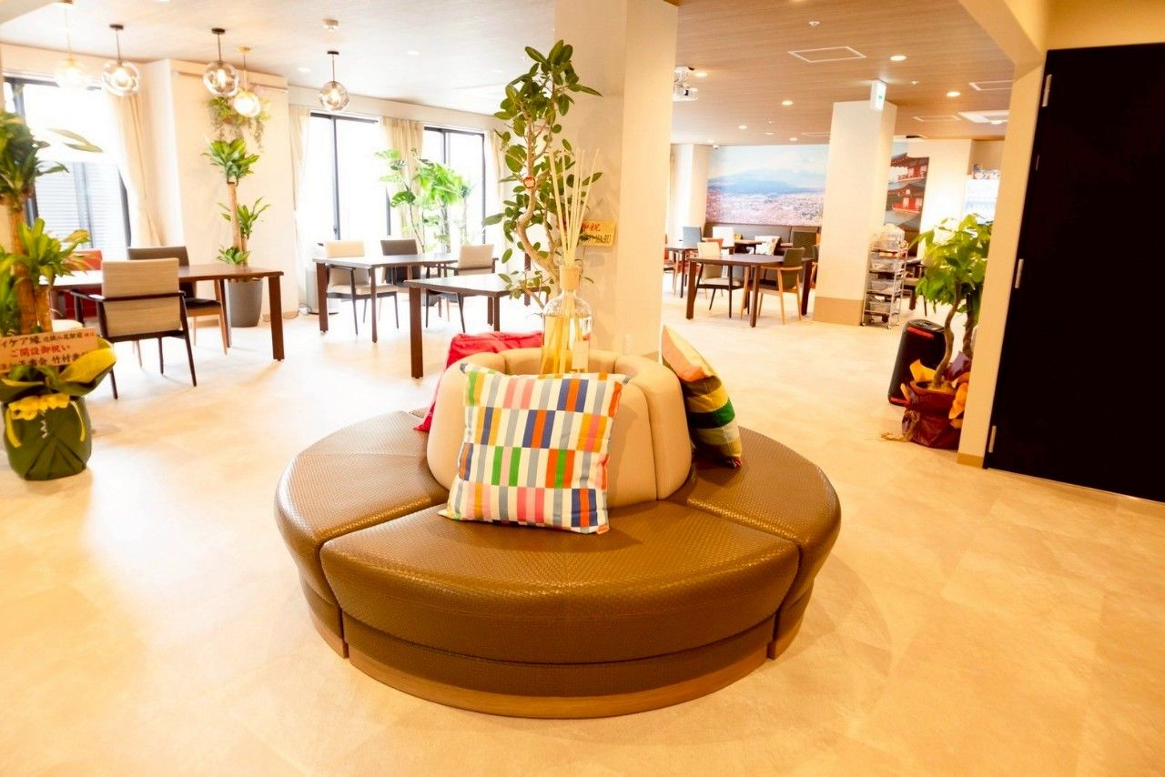 黒からグレーのグラデーションカラーの外壁の5階建て老人ホーム