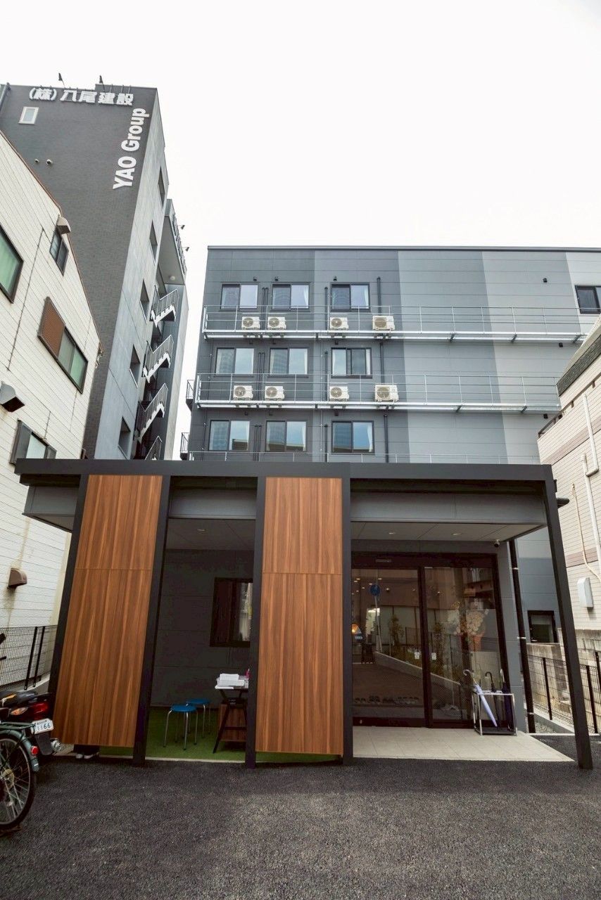 黒からグレーのグラデーションカラーの外壁の5階建て老人ホーム