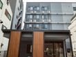黒からグレーのグラデーションカラーの外壁の5階建て老人ホーム
