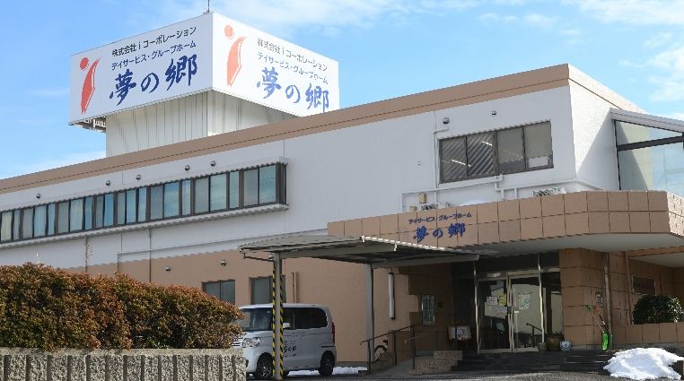 「デイサービス グループホーム 夢の郷」と表示されている2階建てグループホーム