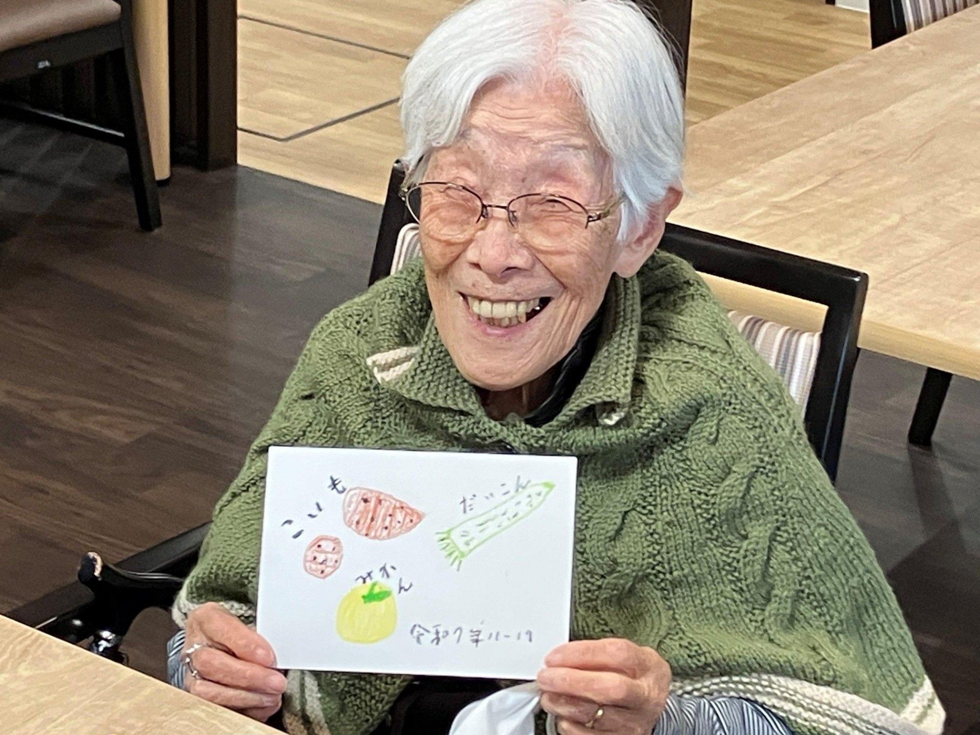 笑顔で絵を持つ女性